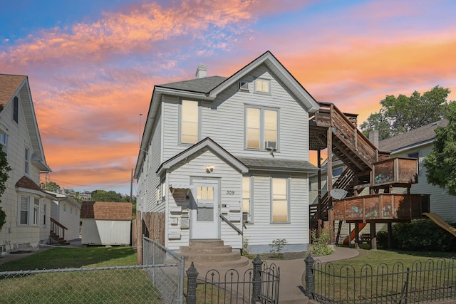 view of front of home with a storage unit, a deck, and a yard