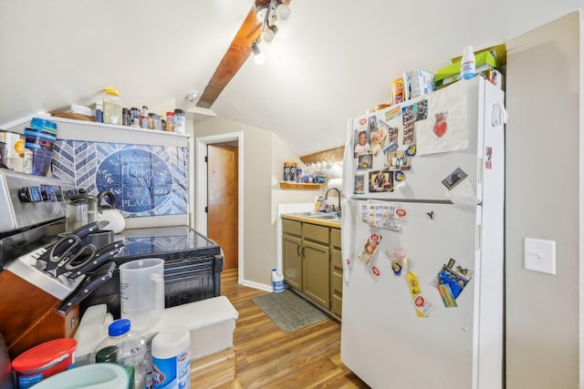 kitchen with green cabinetry, white fridge, light wood-type flooring, lofted ceiling, and sink