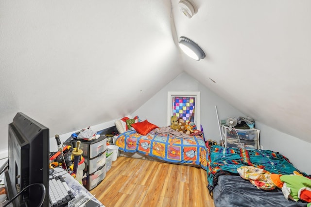 bedroom with vaulted ceiling and hardwood / wood-style flooring