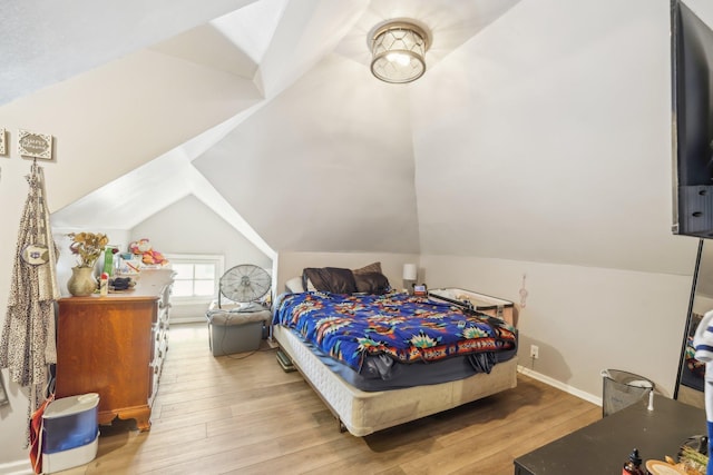 bedroom with light wood-type flooring and lofted ceiling