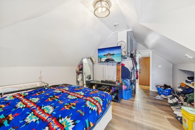 bedroom with light wood-type flooring and vaulted ceiling