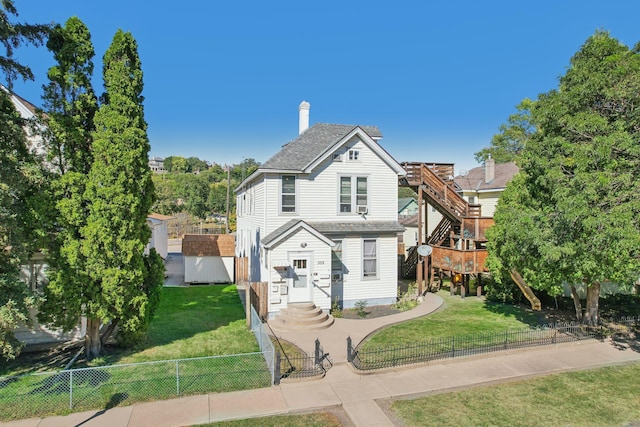 view of front of house with a wooden deck and a front lawn