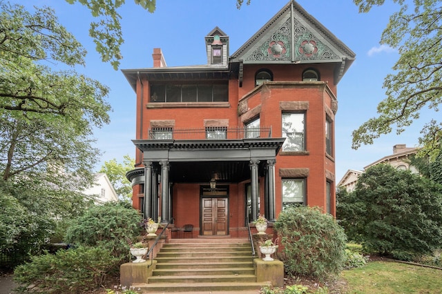 view of front facade featuring a balcony and french doors