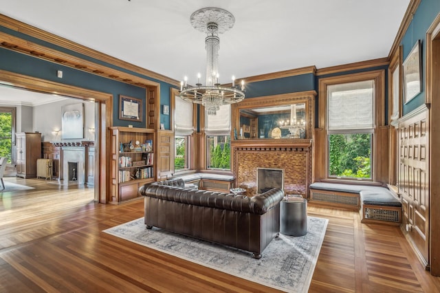 living room featuring crown molding, a healthy amount of sunlight, a notable chandelier, and hardwood / wood-style flooring