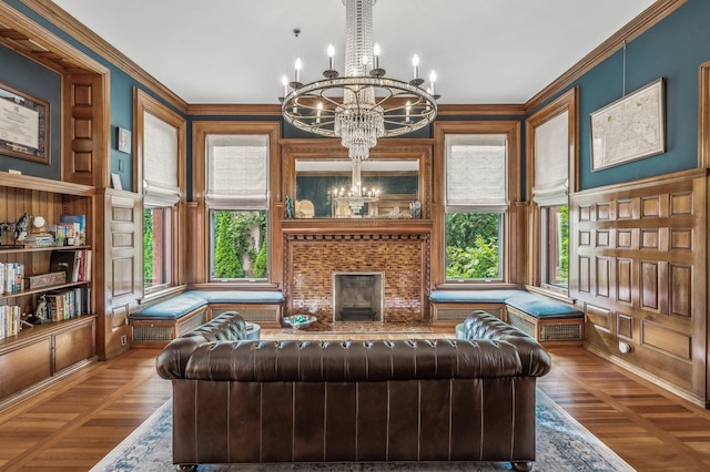 sitting room featuring ornamental molding, a fireplace, parquet flooring, and a chandelier