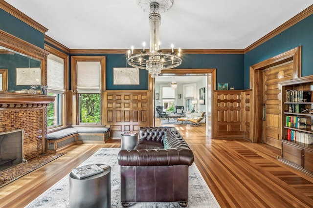 living room with hardwood / wood-style flooring, a notable chandelier, and ornamental molding