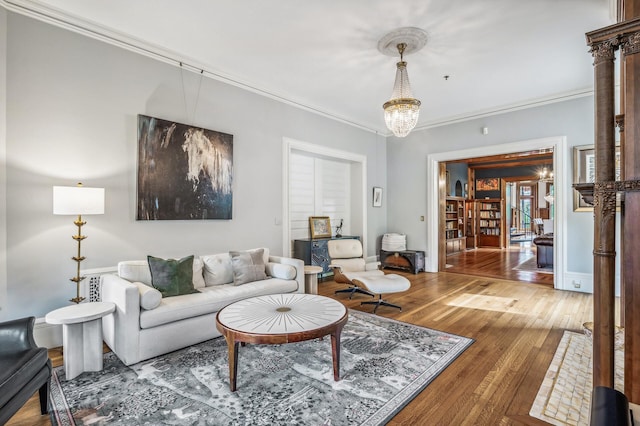 living room with hardwood / wood-style floors, crown molding, and a chandelier