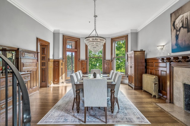 dining space featuring crown molding, radiator heating unit, and dark wood-type flooring