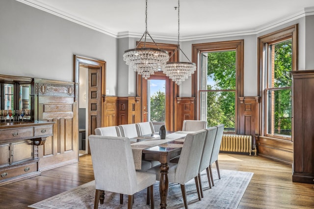 dining area with radiator, ornamental molding, a chandelier, and light hardwood / wood-style floors