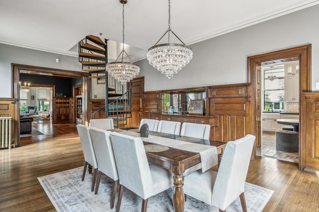 dining room with wood-type flooring, ornamental molding, and an inviting chandelier