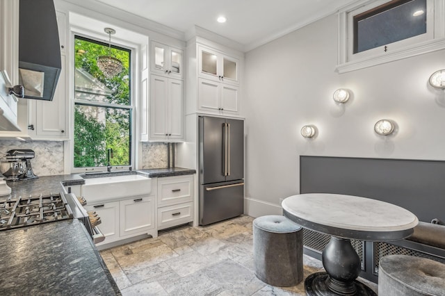 bathroom featuring decorative backsplash, crown molding, a healthy amount of sunlight, and sink