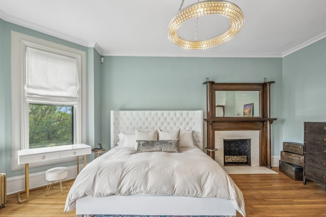 bedroom featuring radiator heating unit, light hardwood / wood-style floors, and ornamental molding