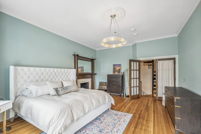 bedroom featuring crown molding and light hardwood / wood-style flooring