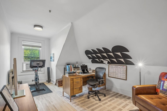 home office with light hardwood / wood-style flooring and lofted ceiling