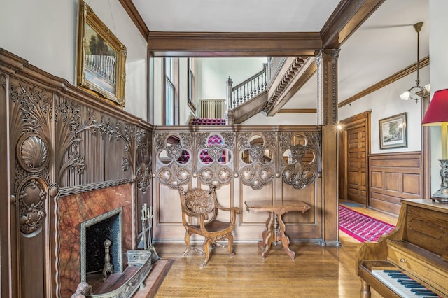 sitting room with ornate columns, crown molding, and wood-type flooring