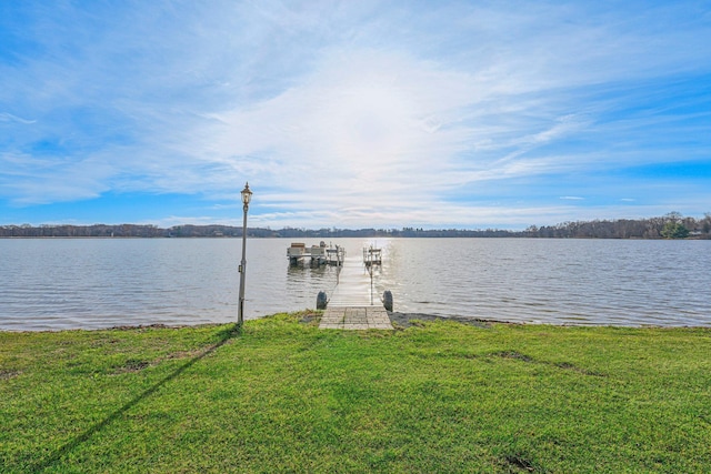 dock area with a water view and a yard