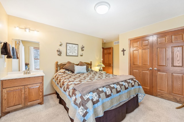 carpeted bedroom with a closet and sink