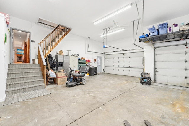 garage with stainless steel fridge with ice dispenser and a garage door opener