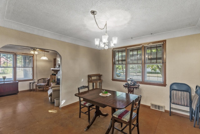 dining space featuring a textured ceiling and ceiling fan with notable chandelier