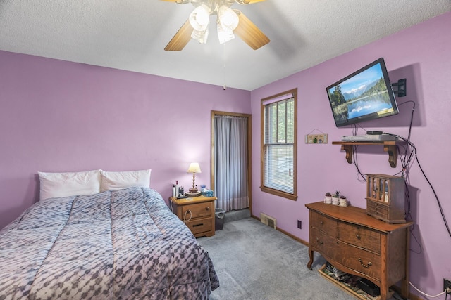 bedroom with light carpet, a textured ceiling, and ceiling fan