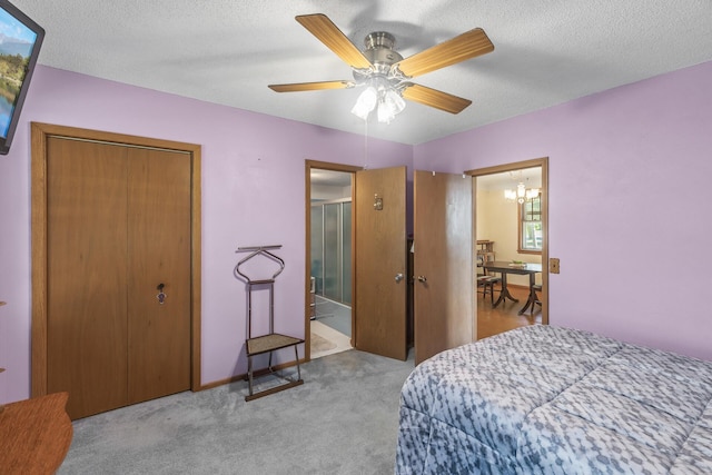 bedroom with a closet, a textured ceiling, ceiling fan with notable chandelier, and light colored carpet