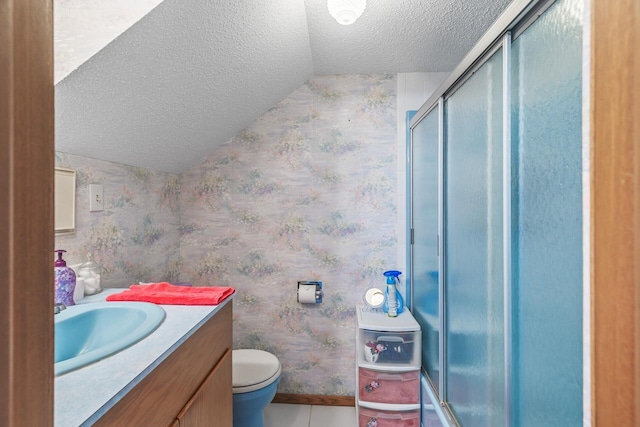 bathroom with vanity, toilet, a textured ceiling, and a shower with door