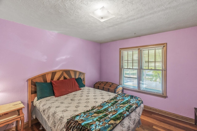 bedroom featuring dark wood-type flooring and a textured ceiling