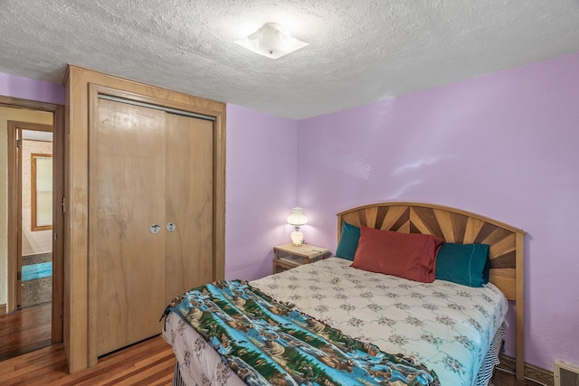 bedroom featuring a closet, hardwood / wood-style floors, and a textured ceiling