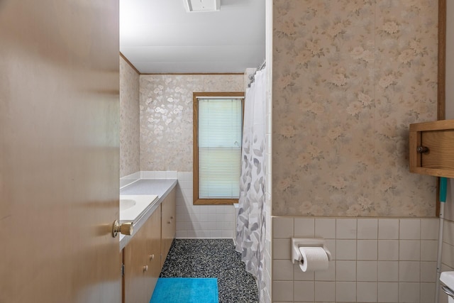 bathroom featuring tile walls, vanity, and toilet