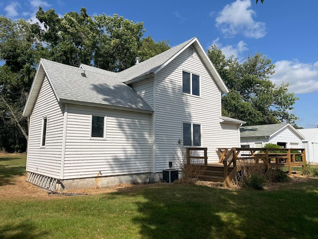 rear view of property with a yard, a deck, and central AC unit