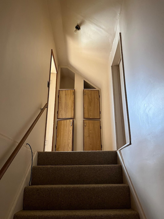 stairway featuring vaulted ceiling