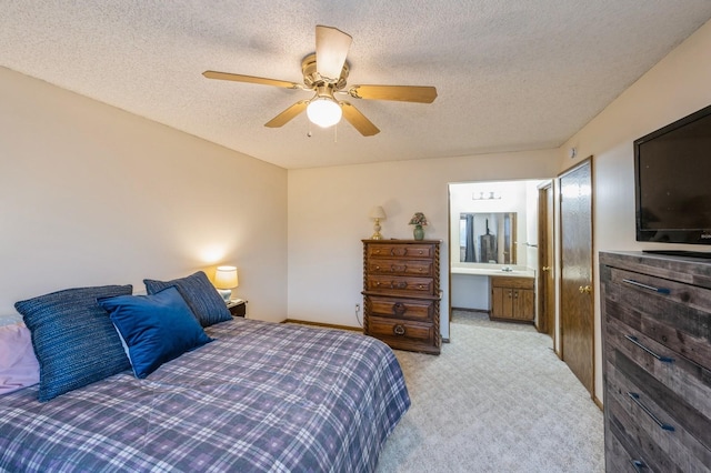 carpeted bedroom with a textured ceiling, ensuite bath, and ceiling fan