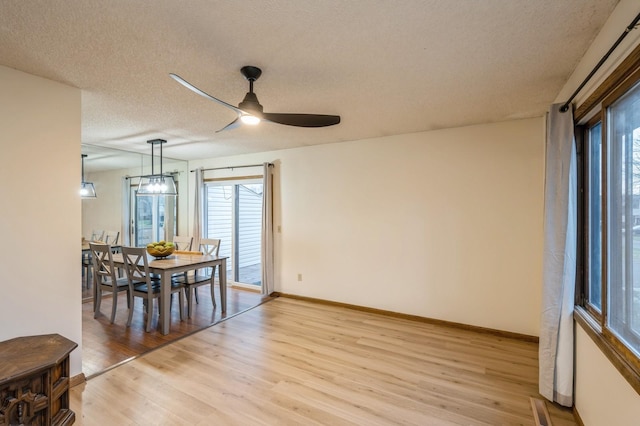 dining space featuring a wealth of natural light, a textured ceiling, ceiling fan, and light hardwood / wood-style flooring