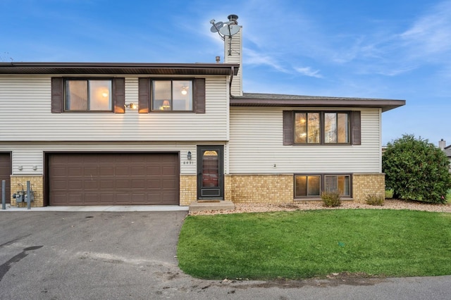 tri-level home with a front lawn and a garage