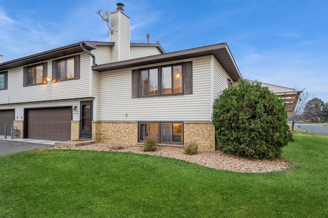 rear view of property featuring a garage and a yard