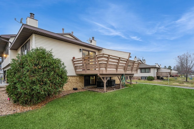 rear view of house featuring a wooden deck, central AC, and a yard