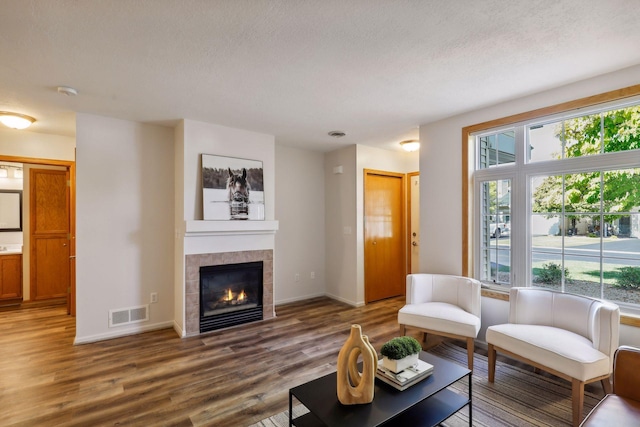 living room featuring a textured ceiling, a fireplace, and hardwood / wood-style flooring