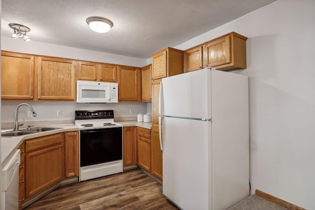 kitchen with dark hardwood / wood-style flooring, white appliances, a textured ceiling, and sink