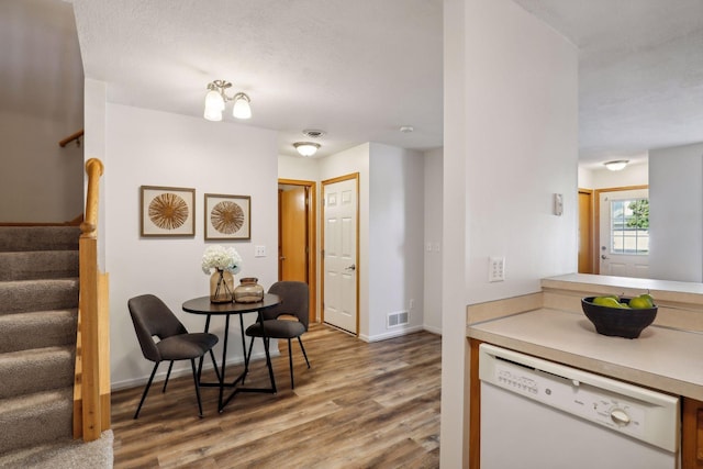 kitchen featuring an inviting chandelier, a textured ceiling, dishwasher, and hardwood / wood-style flooring