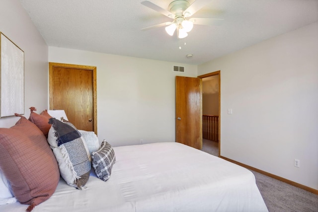 bedroom featuring carpet, ceiling fan, and a textured ceiling