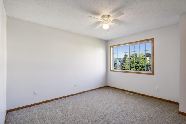 spare room featuring ceiling fan, a textured ceiling, and carpet