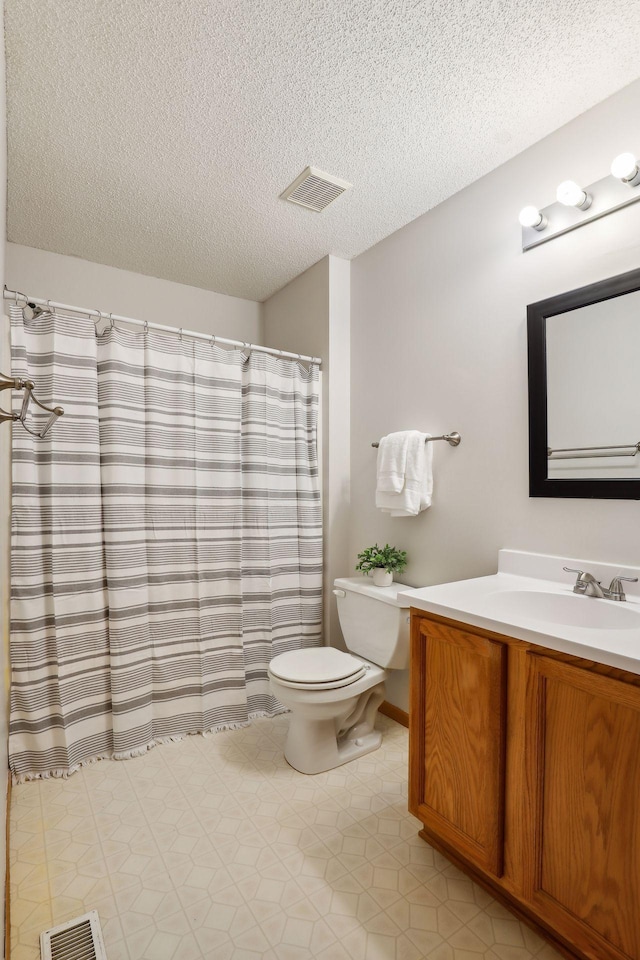 bathroom featuring a textured ceiling, vanity, toilet, and a shower with curtain