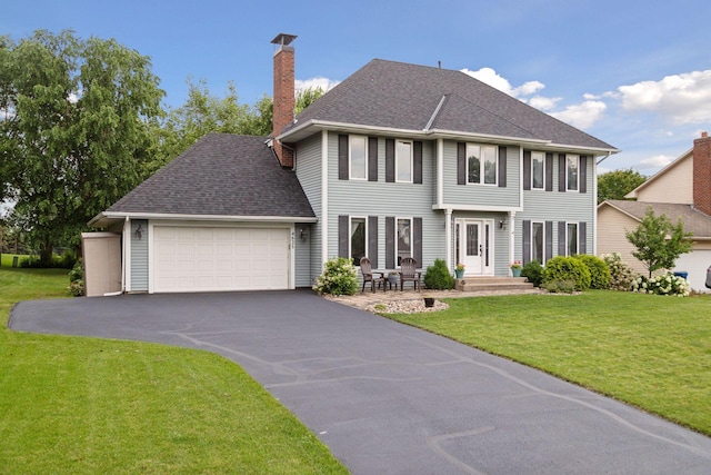 colonial inspired home featuring a front yard and a garage