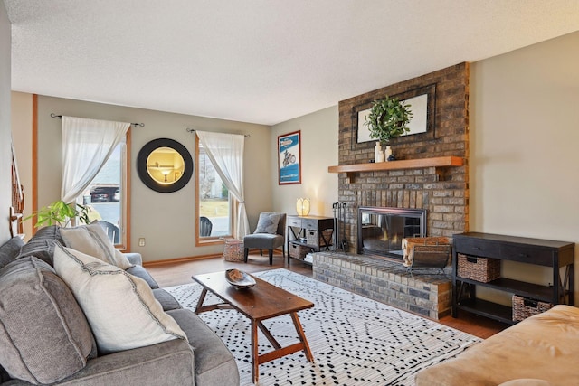 living room with a textured ceiling, a fireplace, and hardwood / wood-style flooring