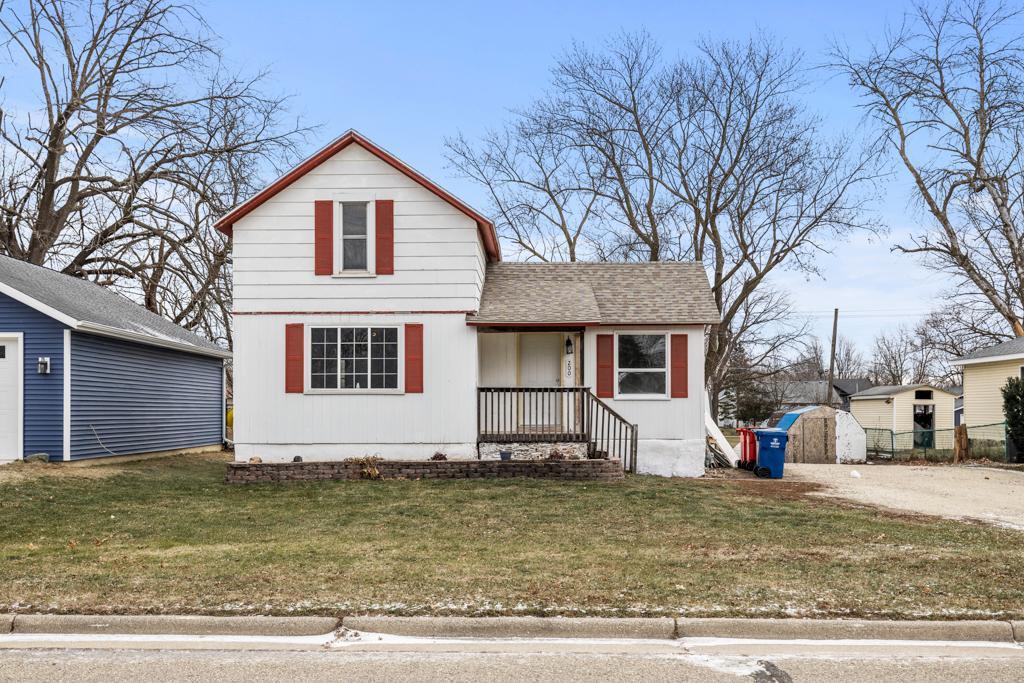 view of front of home with an outdoor structure and a front lawn