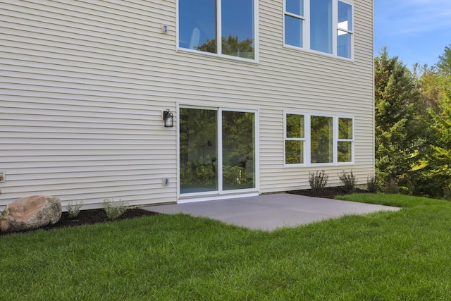 rear view of house with a lawn and a patio area