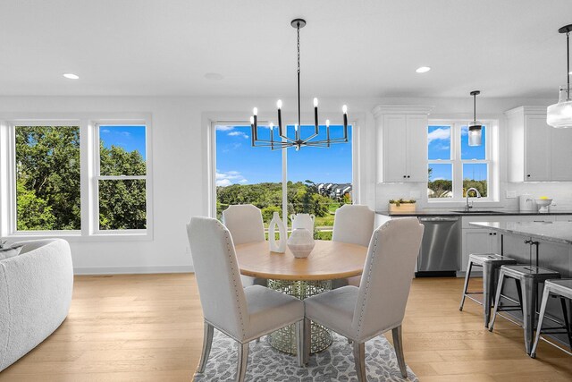 dining space with light wood-type flooring, sink, and plenty of natural light