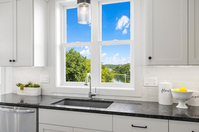 kitchen with white cabinetry, tasteful backsplash, dishwasher, pendant lighting, and sink