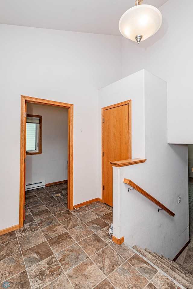 empty room with vaulted ceiling and baseboard heating