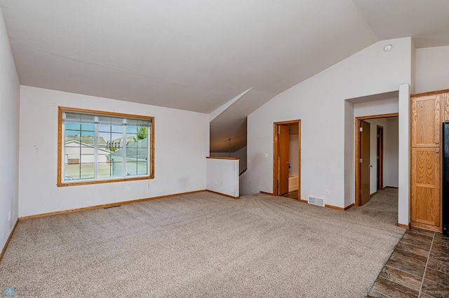 interior space featuring lofted ceiling and dark colored carpet